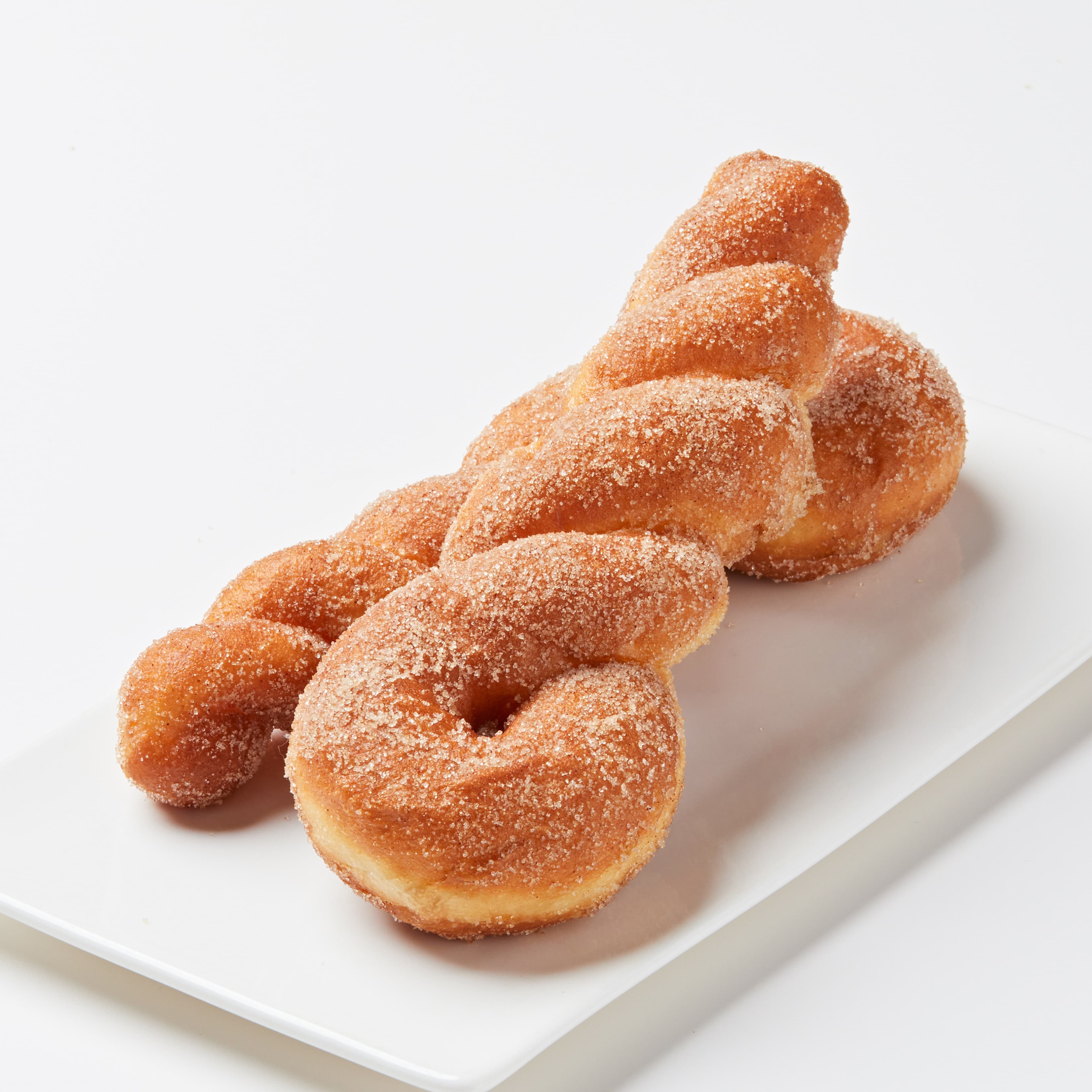 Cinnamon Sugar Twist Donut - A fluffy, hand-twisted donut coated in a light cinnamon sugar blend. Soft on the inside, perfectly crisp on the outside, and packed with nostalgic flavor.