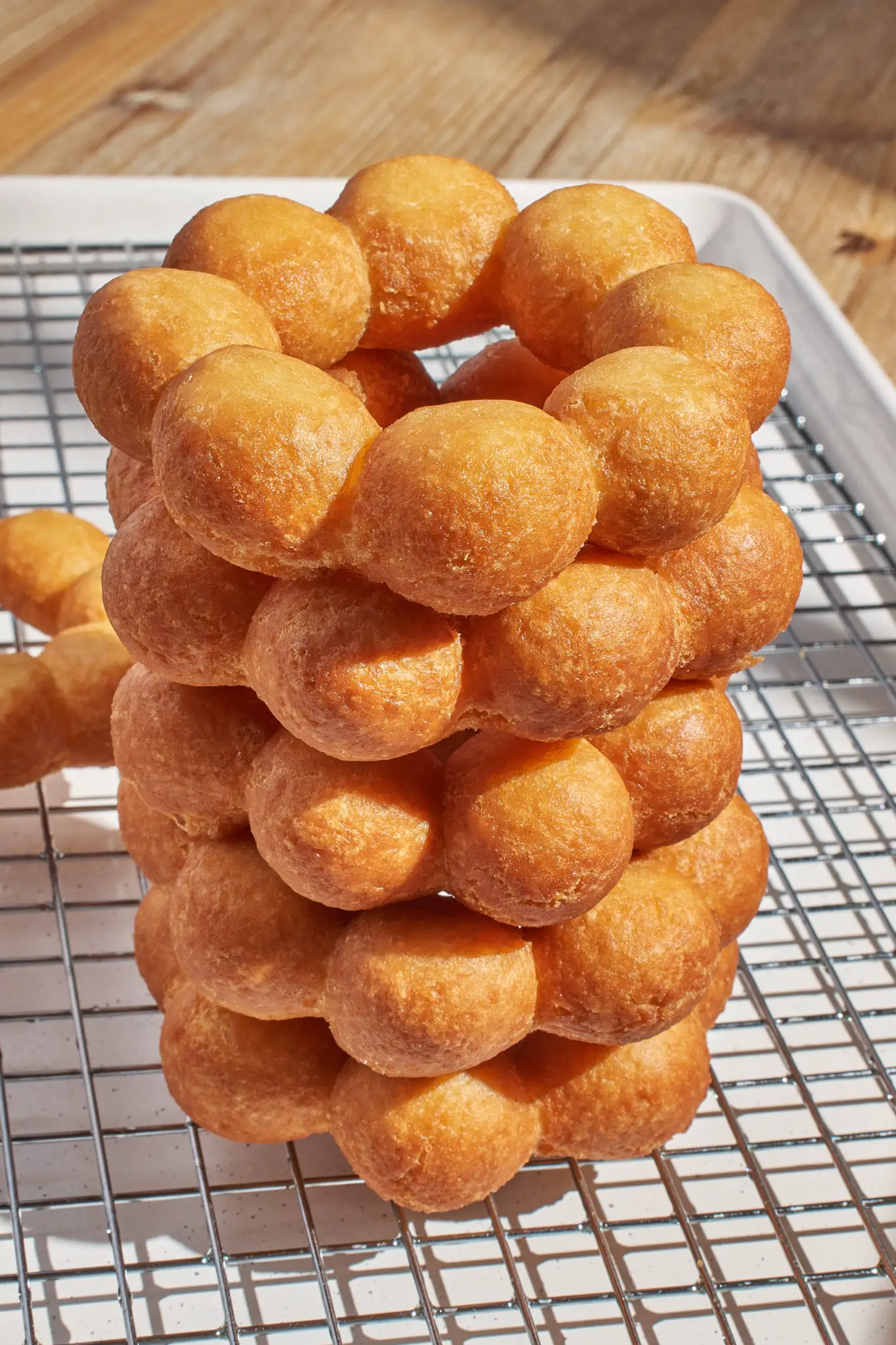 Freshly glazed mochi donuts stacked on a tray